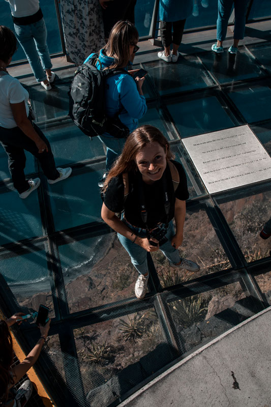 Chrissi steht auf dem Glasboden des Cabo Girão Skywalk auf Madeira